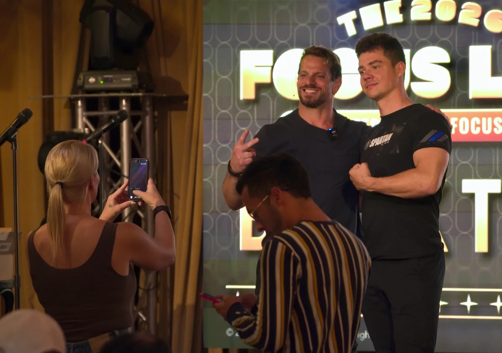 A guest taking a photo with Jarred Curcio on stage at The Focus Lab in Austin, Texas