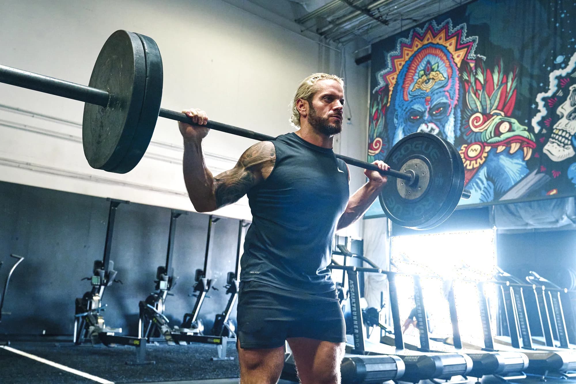 Jarred Curcio standing with a loaded barbell racked at his shoulders during training in Austin, Texas